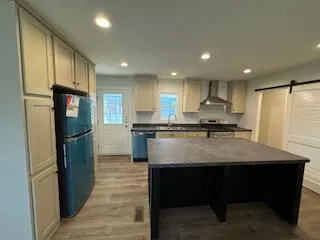a kitchen with kitchen island a refrigerator stove a sink and a oven