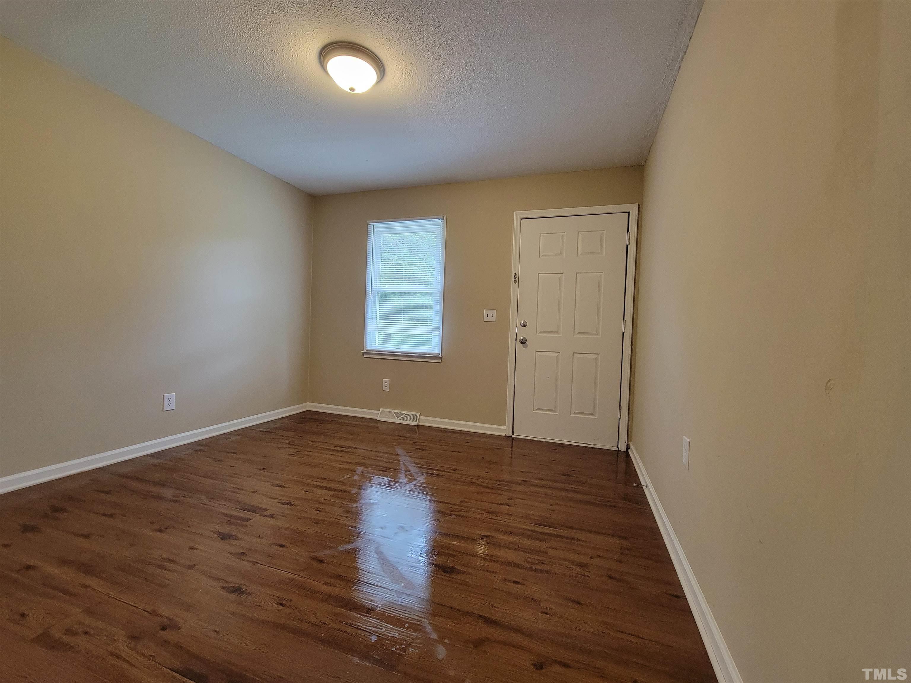 7137 Hodge Road Wendell, NC 27591 - Photo 3 of 31 a view of an empty room with wooden floor and a window