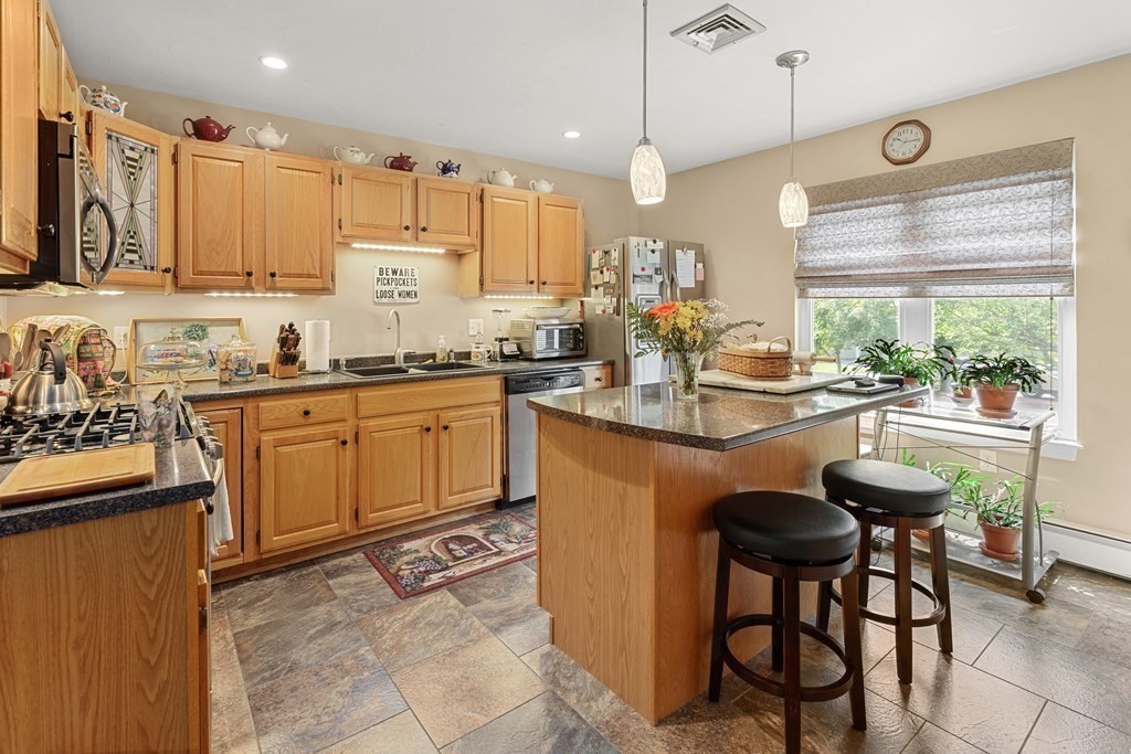 a kitchen with sink a window and chairs