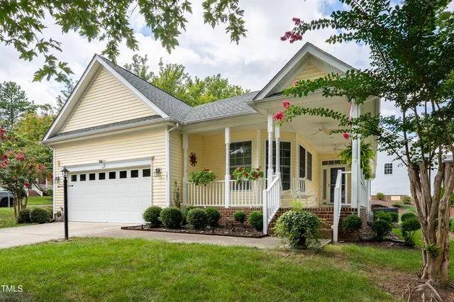 front view of house with a yard and potted plants