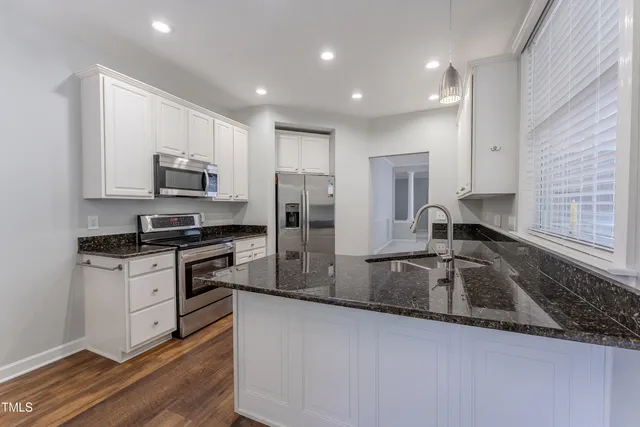 a kitchen with kitchen island a sink appliances and cabinets