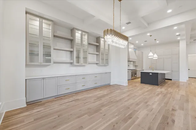 a view of a kitchen with stainless steel appliances kitchen island a large counter top and wooden floor
