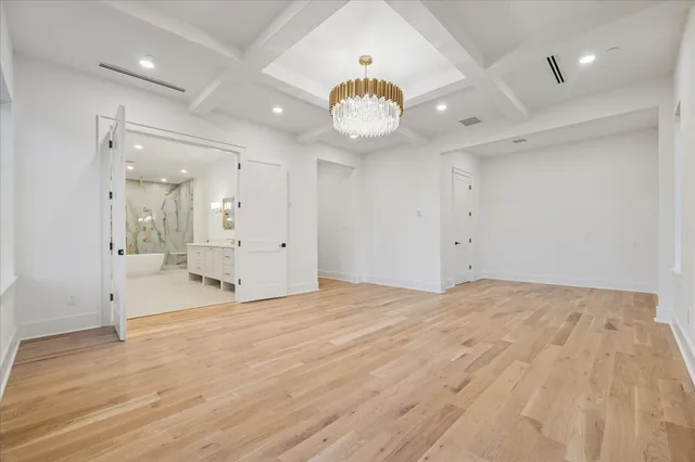 an empty room with wooden floor and mirror