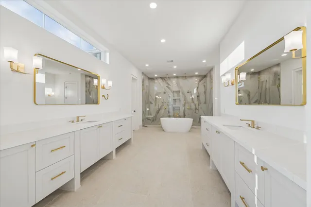 a large bathroom with a double vanity sink and mirror with toilet
