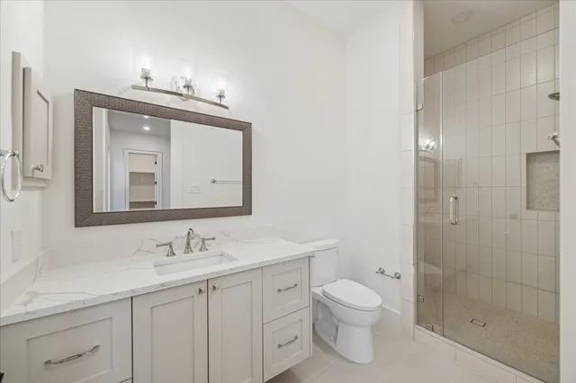 a bathroom with a granite countertop sink a toilet and a mirror