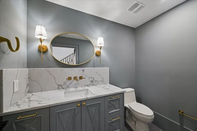 a bathroom with a toilet sink and mirror