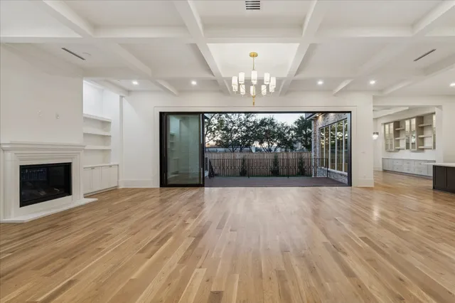 a view of empty room with wooden floor and fireplace