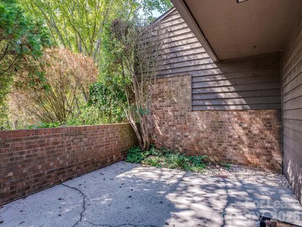 a front view of a house with a large tree