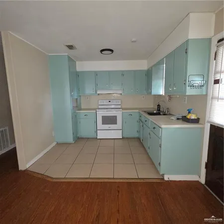 a kitchen with a sink a stove and cabinets
