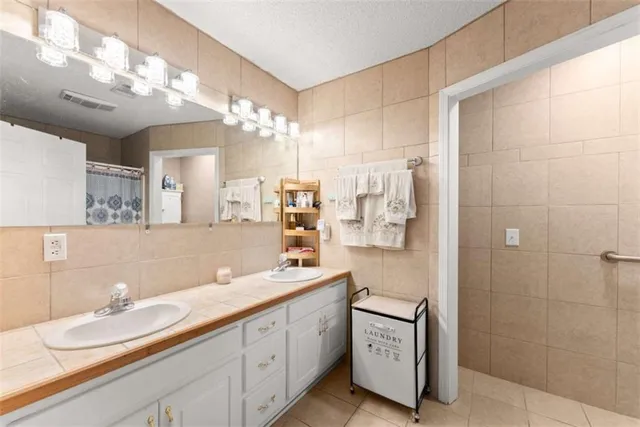 a bathroom with a double vanity sink mirror and shower