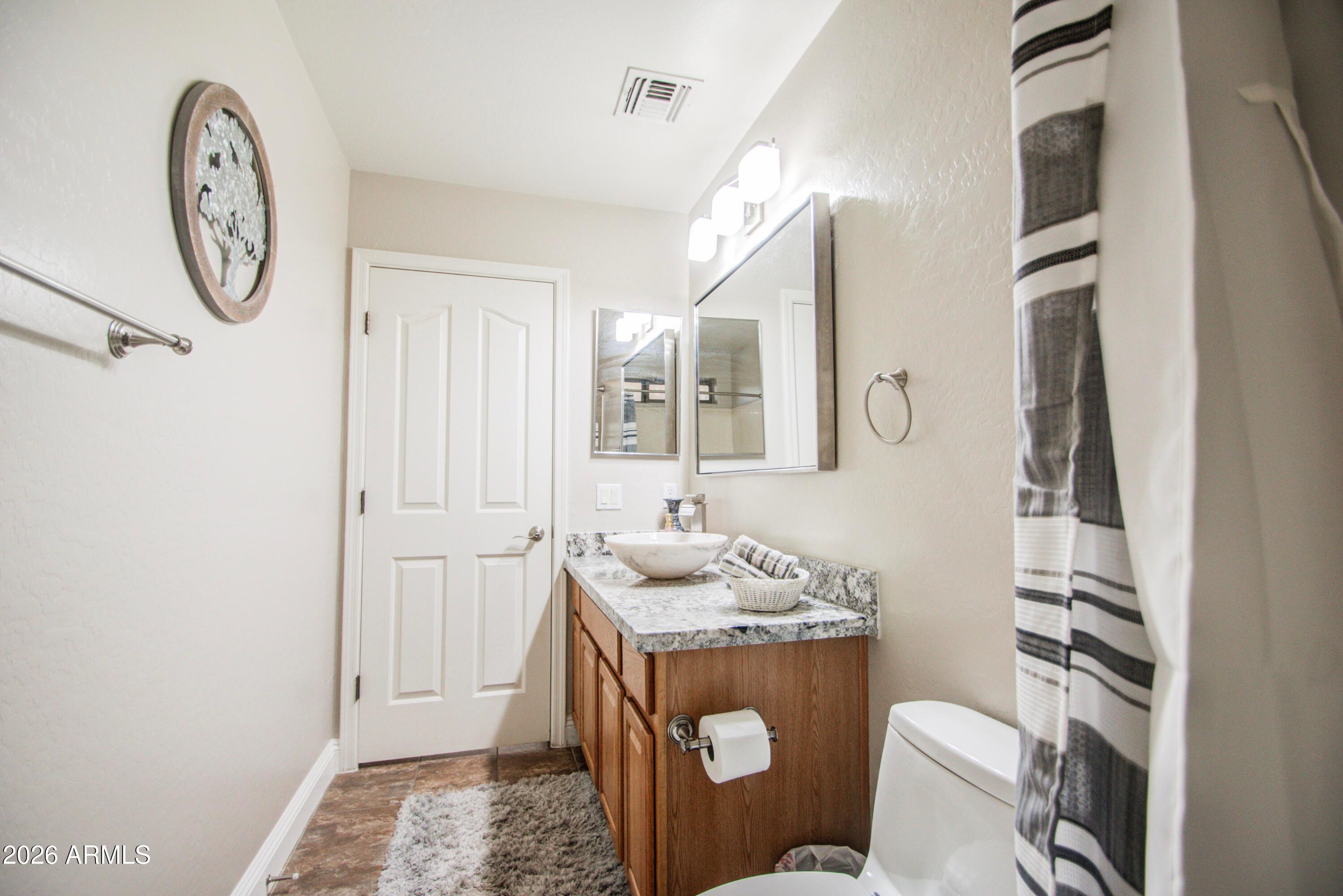 43205 Roth Road Maricopa, AZ 85138 - Photo 16 of 44 a bathroom with a sink mirror vanity and toilet
