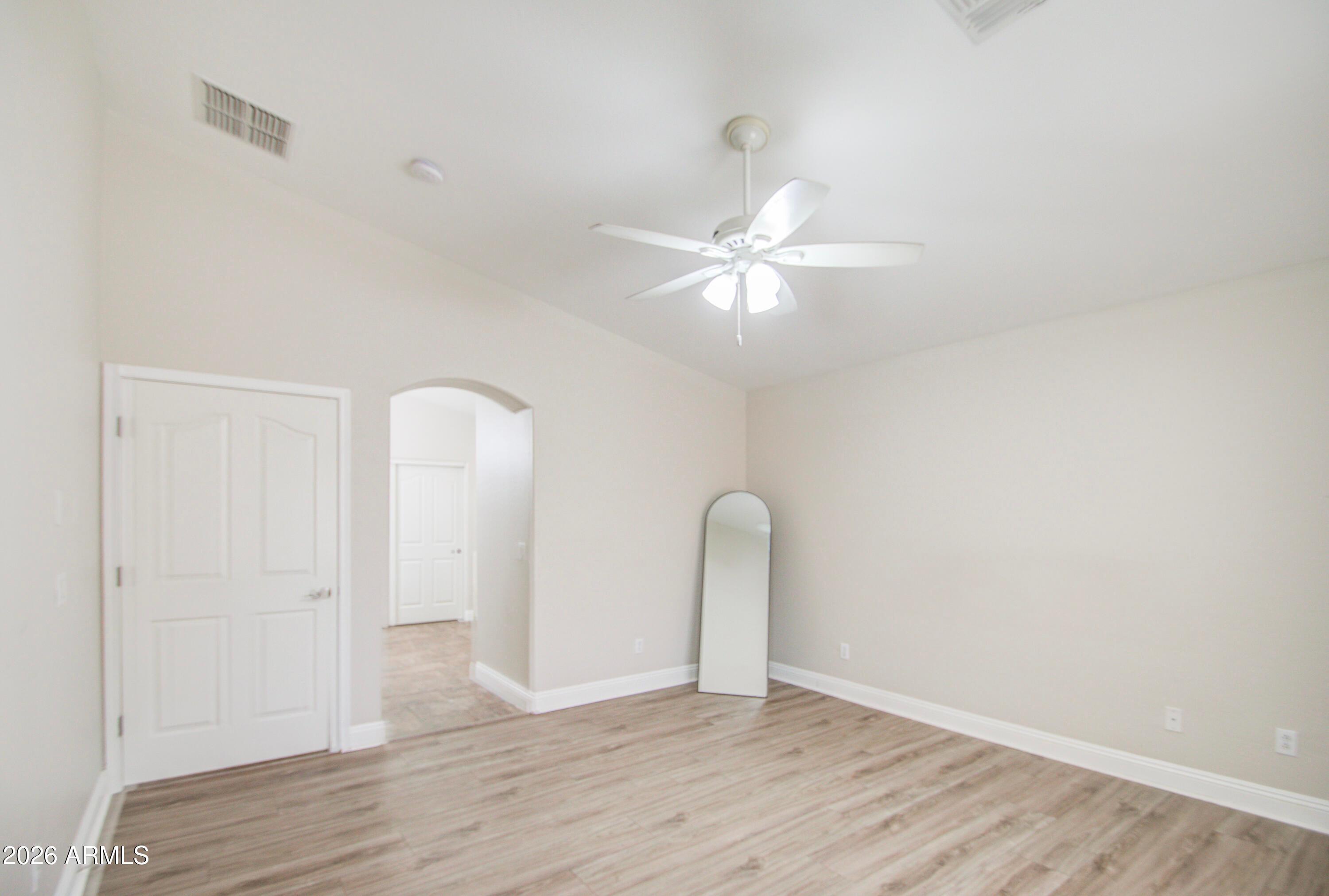 43205 Roth Road Maricopa, AZ 85138 - Photo 26 of 44 an empty room with wooden floor and ceiling fan