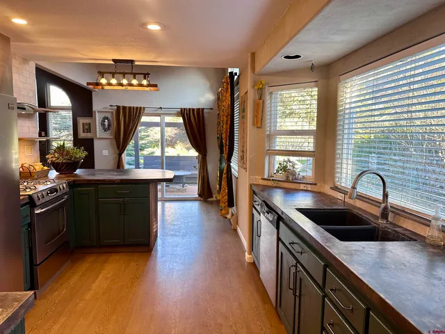 an empty room with wooden floor closet and windows