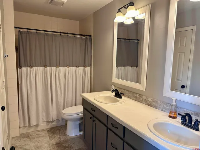 a bathroom with a sink a toilet and mirror