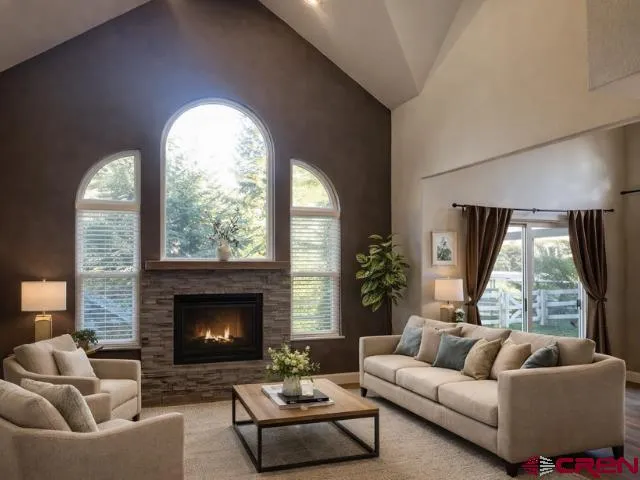 an empty room with wooden floor a fireplace and windows