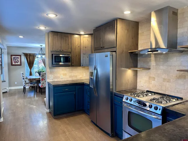 a kitchen with kitchen island granite countertop wooden cabinets and stainless steel appliances