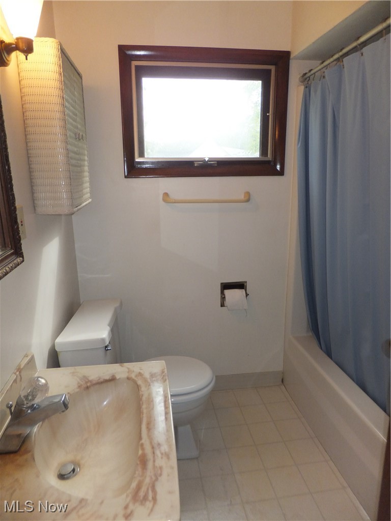 5113 Snow Road Cleveland, OH 44134 - Photo 27 of 40 Full bathroom with shower / tub combo with curtain, toilet, sink, and tile patterned floors