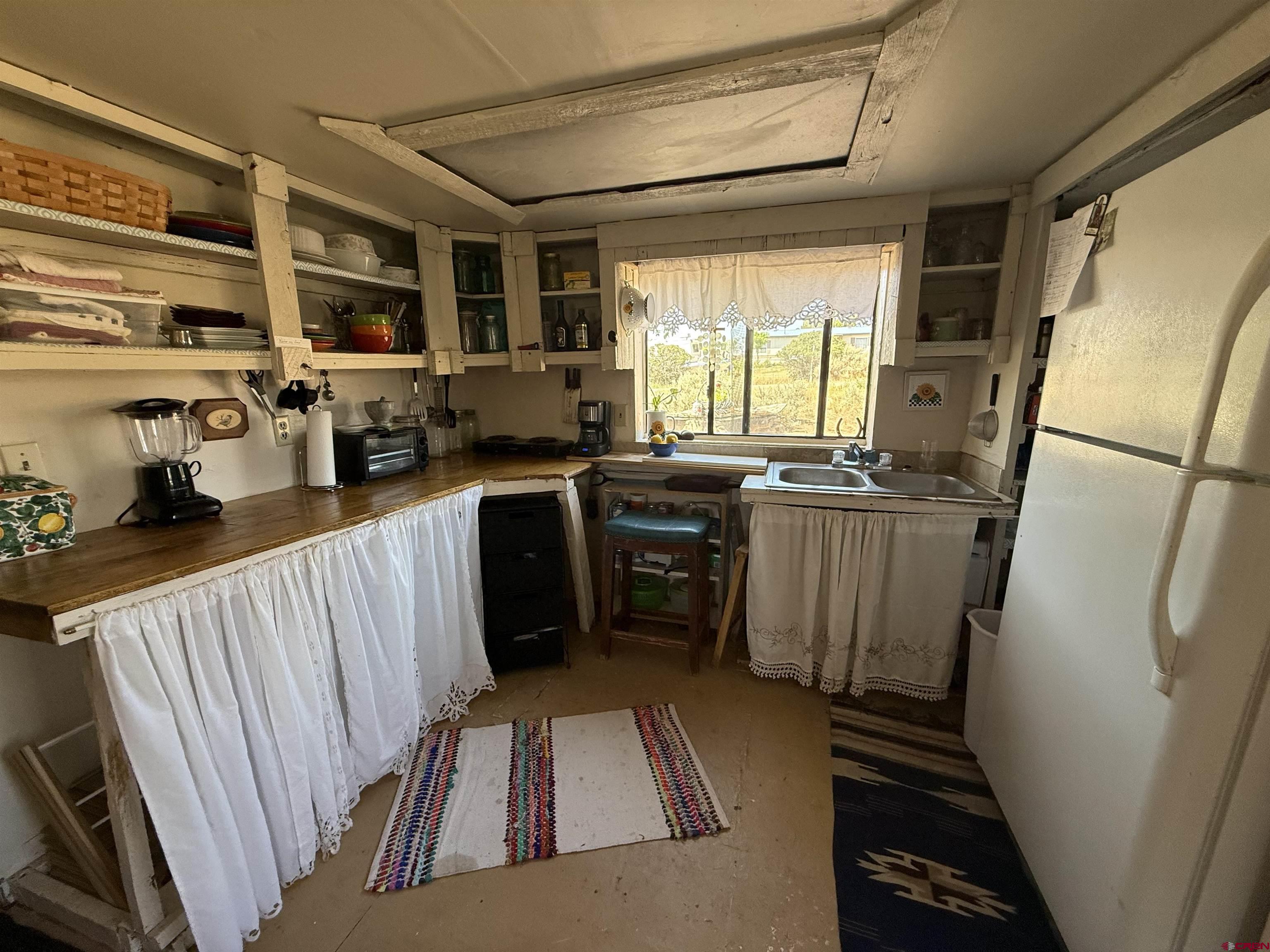 12730 Rd R Cahone, CO 81320 - Photo 7 of 34 a kitchen with stainless steel appliances a refrigerator a sink a stove and white cabinets