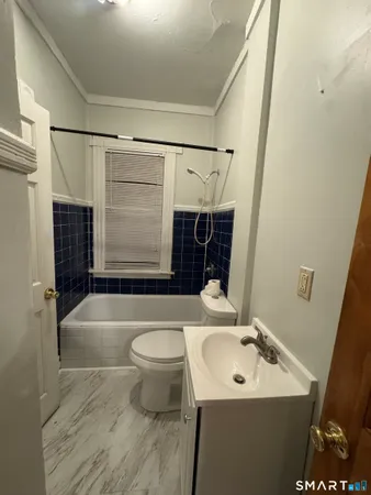 a bathroom with a sink a toilet a mirror and bathtub