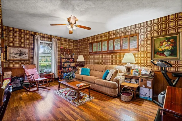 a living room with furniture a flat screen tv and a floor to ceiling window