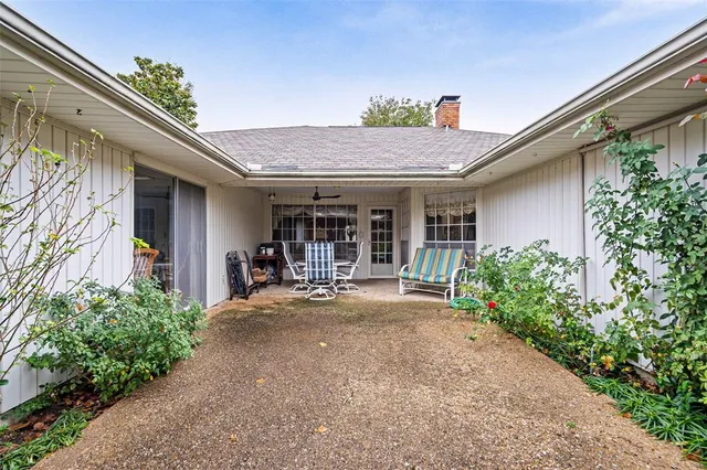 a view of a backyard with furniture and garden