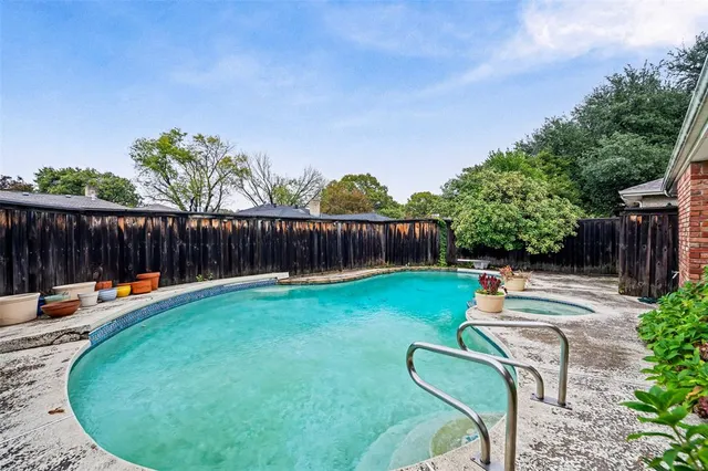 a view of a backyard with swimming pool and outdoor seating