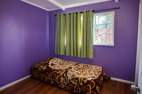 a bed sitting in a bedroom next to a window