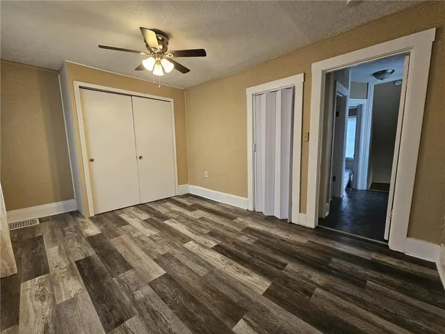 a view of a livingroom with wooden floor and a ceiling fan