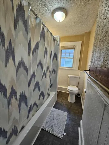 a bathroom with a toilet and a shower