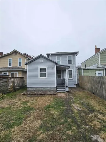 a view of a house with a yard and fence