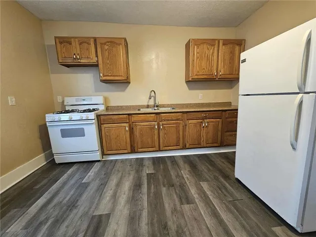 a kitchen with wooden floors and white appliances