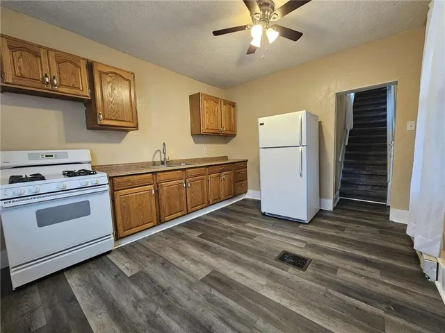 a kitchen with stainless steel appliances granite countertop a stove a sink and a refrigerator