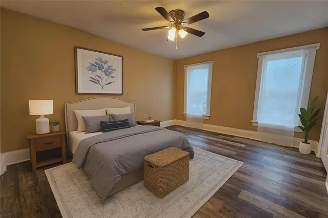 a spacious bedroom with a bed and a potted plant on the dresser