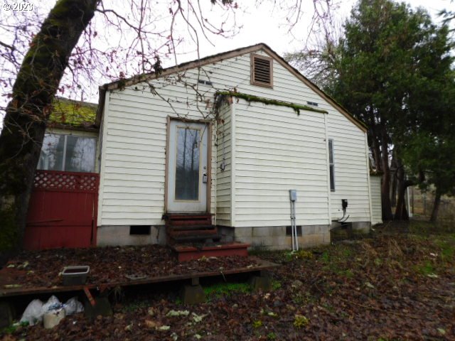 36874 Wallace Creek Road Springfield, OR 97478 - Photo 17 of 18 a view of a white house with a yard and potted plants