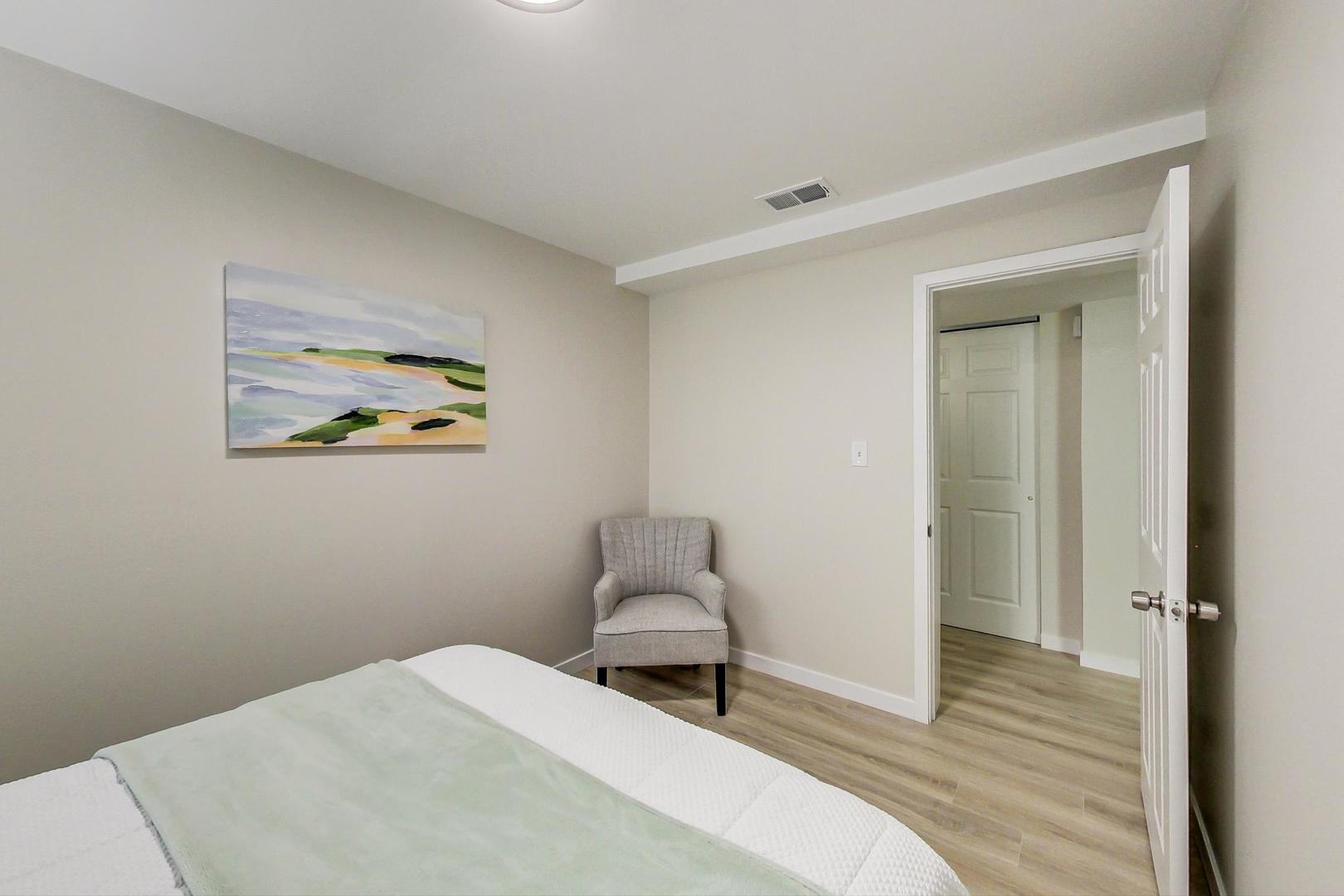 613 North Racine Avenue, Unit 1 Chicago, IL 60642 - Photo 16 of 21 a bedroom with a bed and a painting on the wall