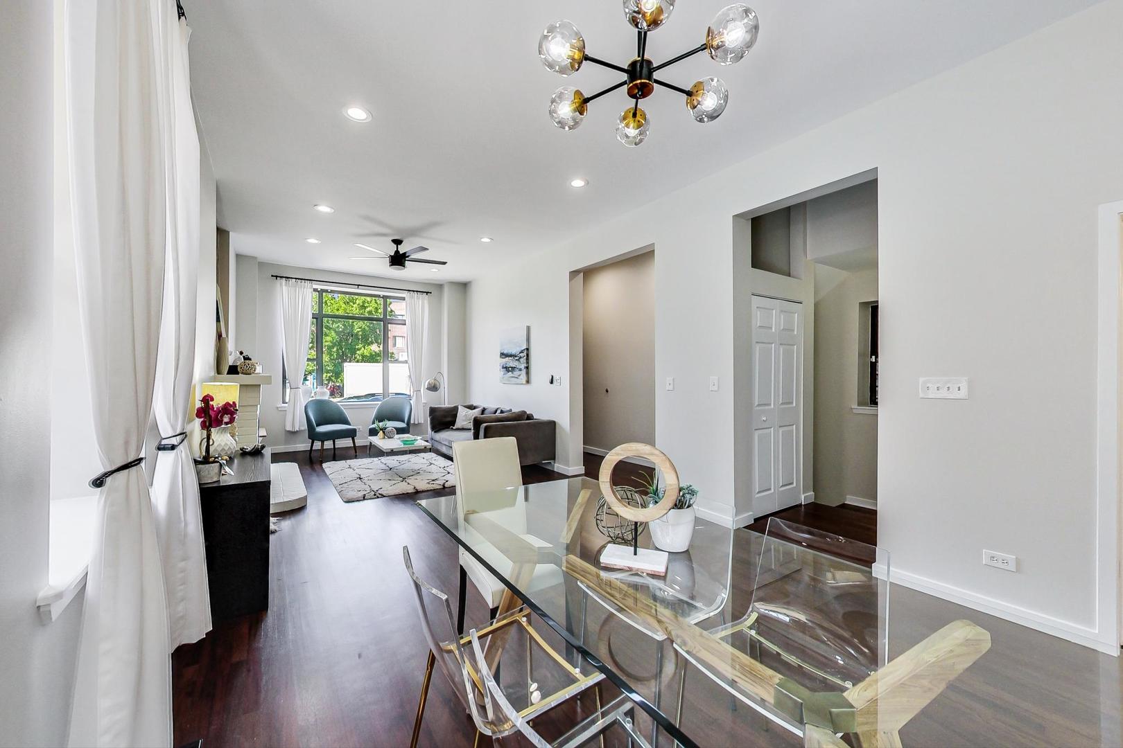 613 North Racine Avenue, Unit 1 Chicago, IL 60642 - Photo 5 of 21 a view of a dining room and livingroom with furniture a rug a chandelier and wooden floor