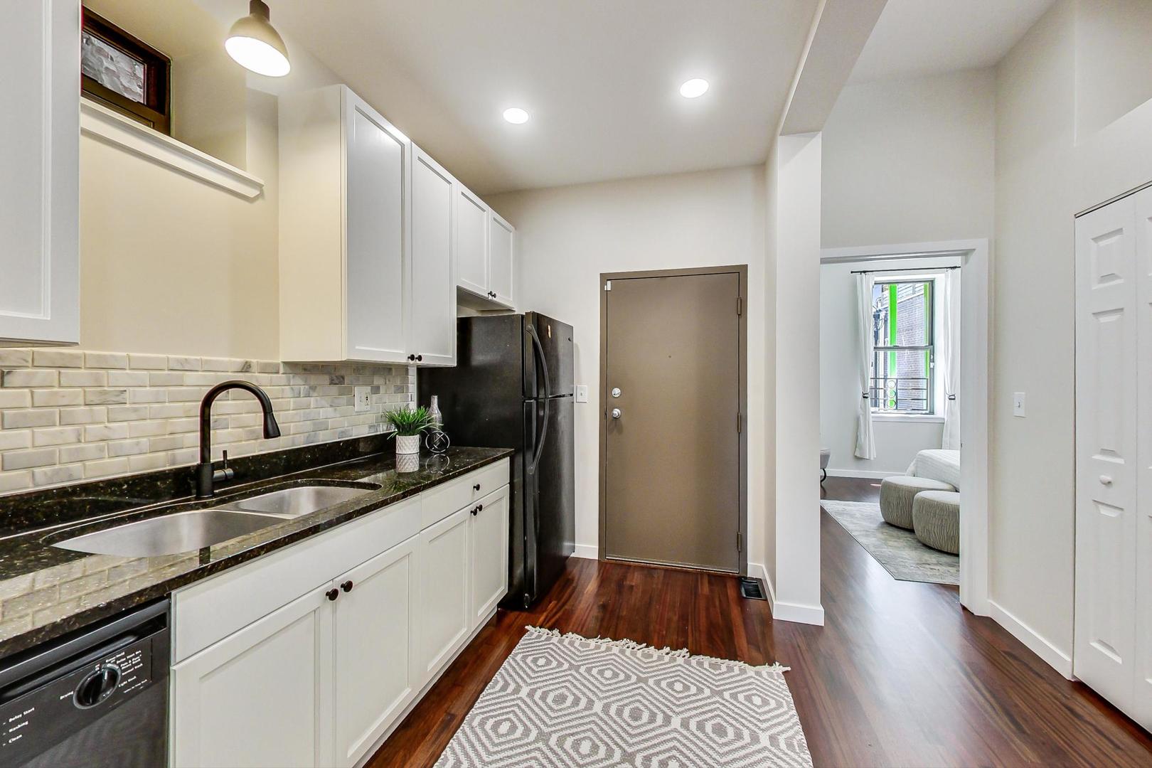 613 North Racine Avenue, Unit 1 Chicago, IL 60642 - Photo 7 of 21 a kitchen with a sink and a refrigerator