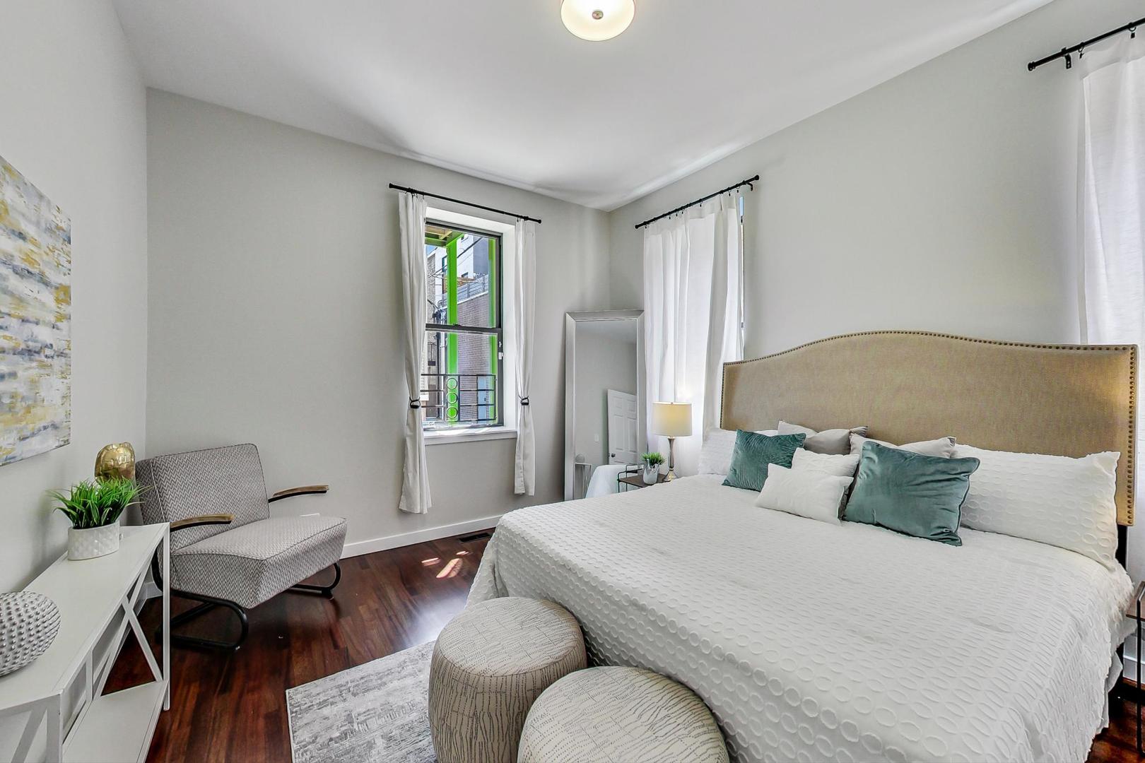 613 North Racine Avenue, Unit 1 Chicago, IL 60642 - Photo 8 of 21 a bedroom with a bed and wooden floor