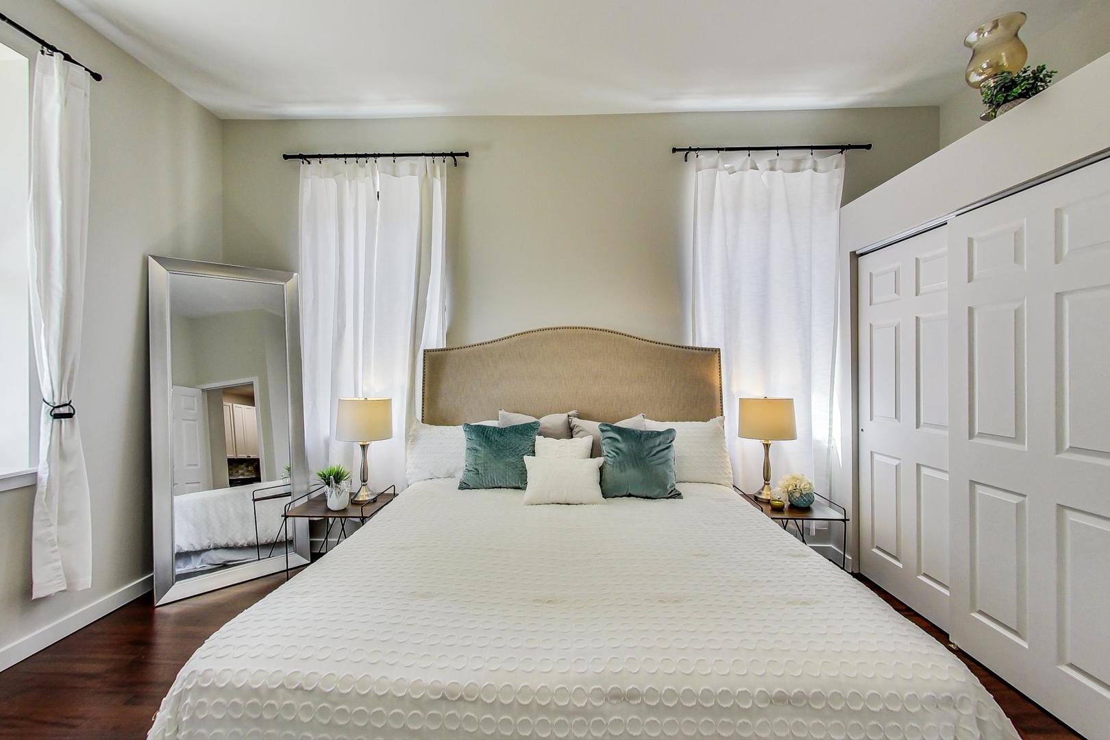 613 North Racine Avenue, Unit 1 Chicago, IL 60642 - Photo 9 of 21 a bedroom with a large bed and wooden floor