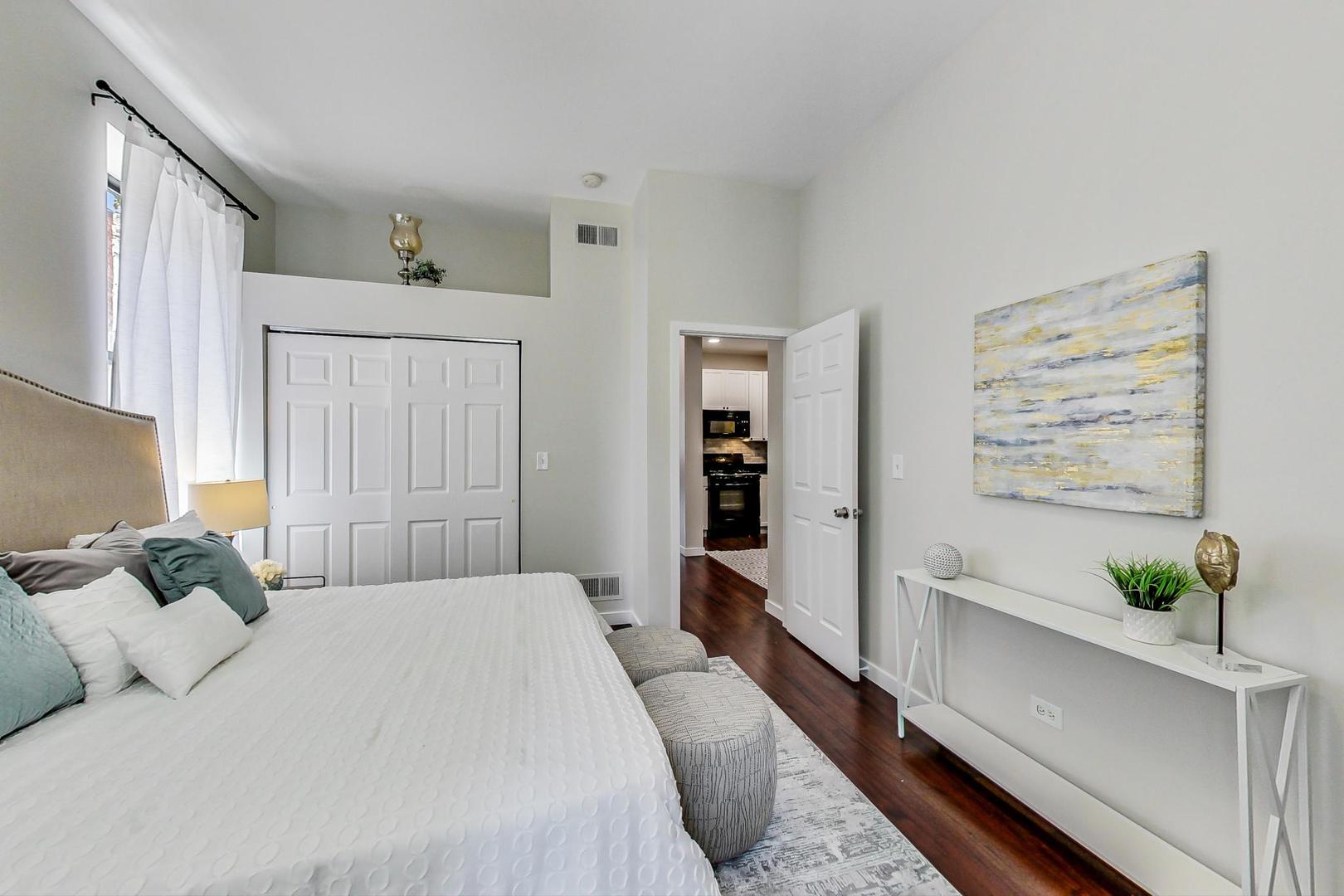 613 North Racine Avenue, Unit 1 Chicago, IL 60642 - Photo 10 of 21 a spacious bedroom with a bed and a potted plant