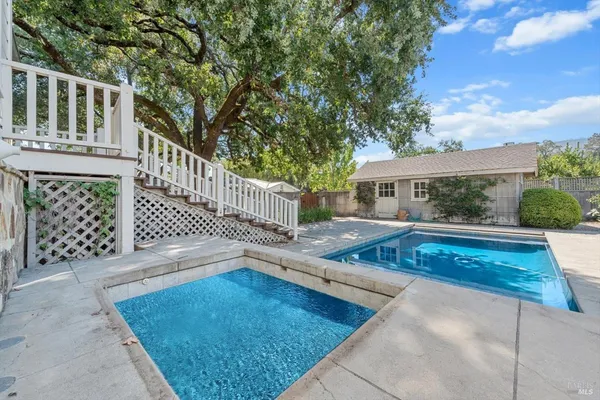 a view of house with swimming pool and sitting area