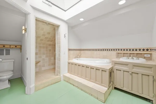 a bathroom with a tub a sink and a view of bathroom