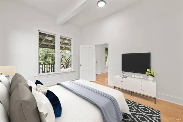 a bedroom with a bed and a flat screen tv