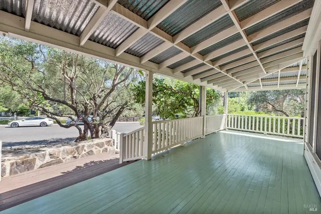 a view of a porch with wooden floor and wooden fence