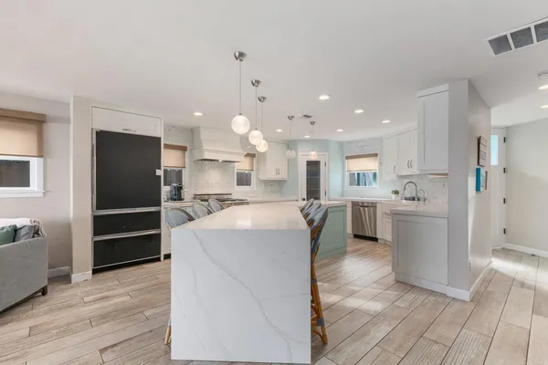 a kitchen with white cabinets sink and window