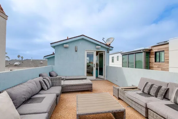 a view of a roof deck with couches under an umbrella