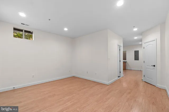 a view of a big room with wooden floor and windows