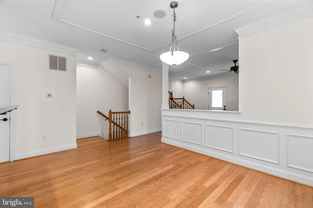 a view of an empty room with window and wooden floor