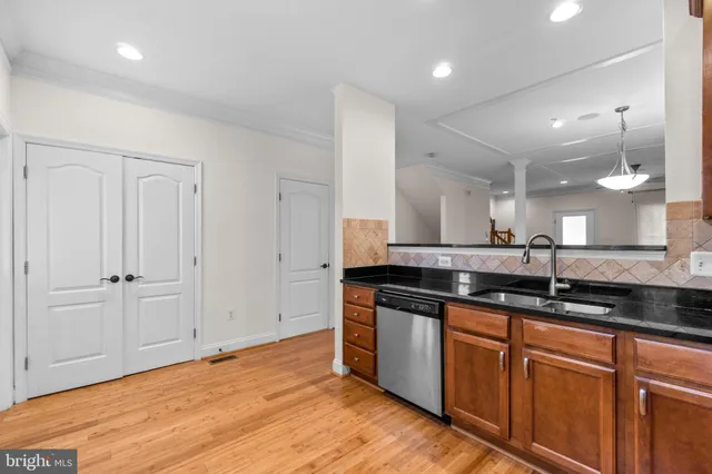 a large kitchen with stainless steel appliances granite countertop a sink and a wooden floors