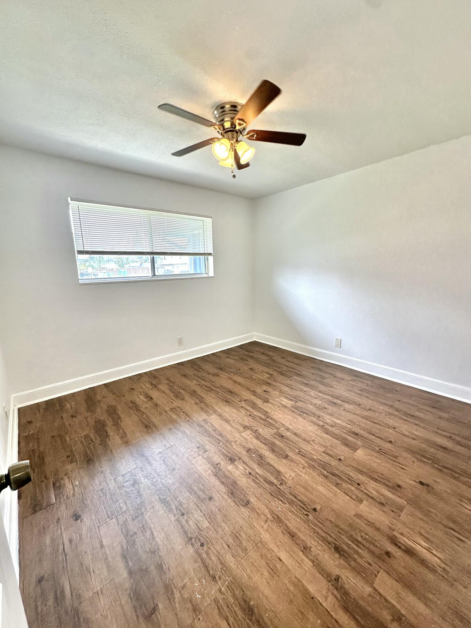 210 Tiffany Drive East, Unit 1 West Palm Beach, FL 33407 - Photo 2 of 10 wooden floor in an empty room